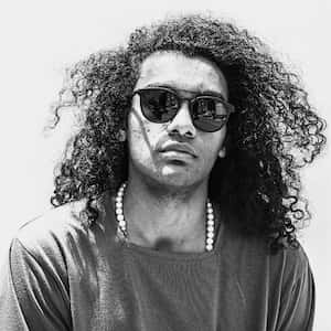 Man with curly hair wearing sun glasses